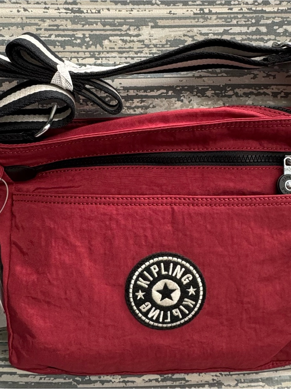 Kipling Red Crossbody Bag with Black-and-White Striped Strap